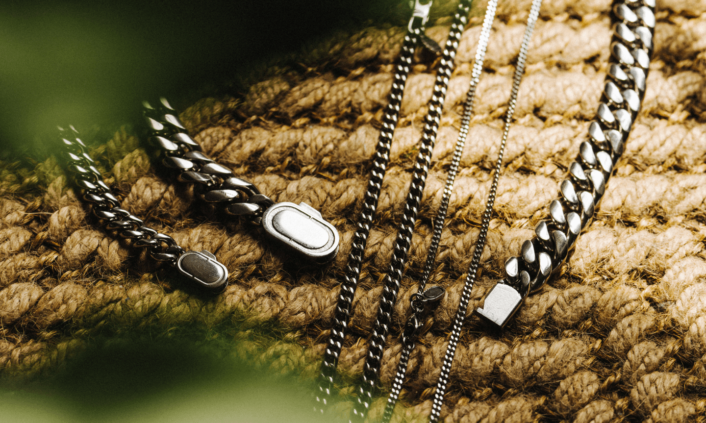 Sterling Silver Cuban Link Chain lay on a textured brown table