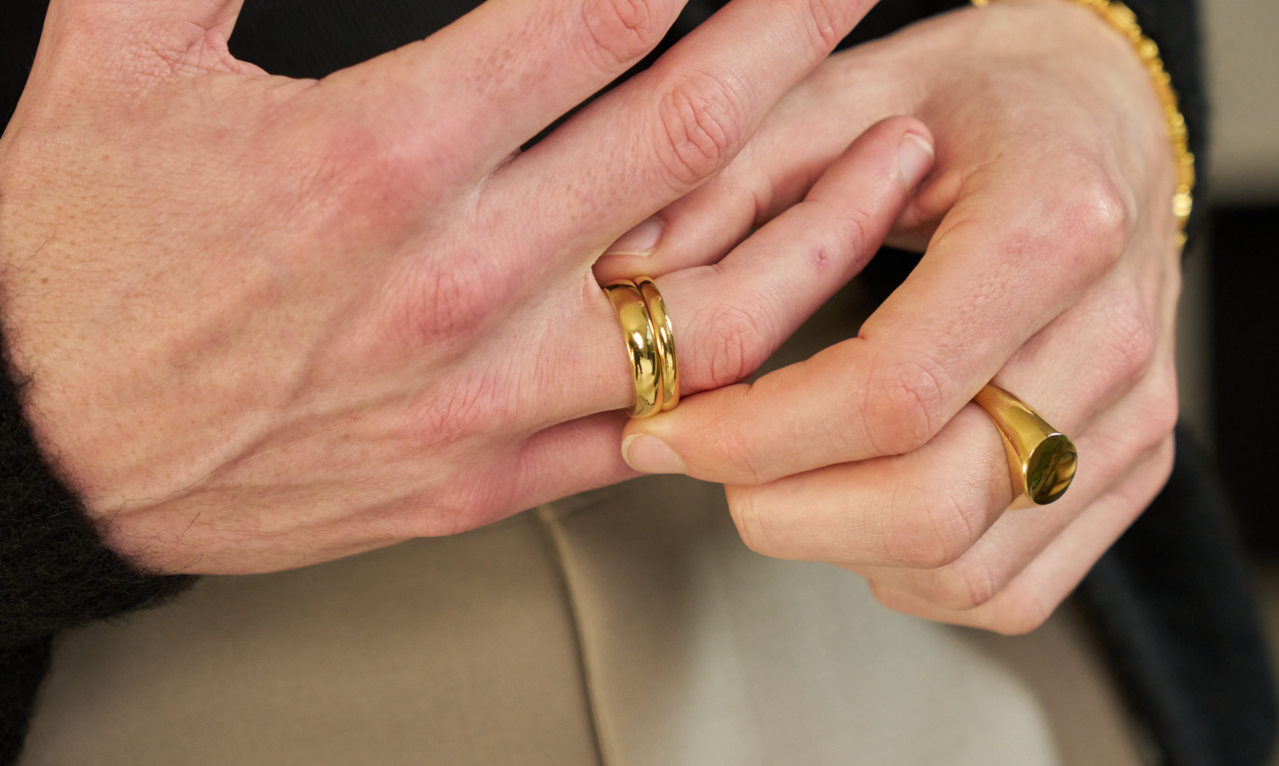 Man's hand wearing a Gold Plated Tungsten Wedding Band
